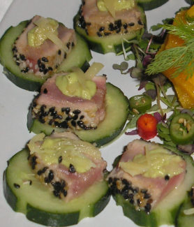 A plate of food with tuna and cucumber.