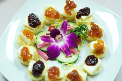 A plate of food with flowers and jam on it.