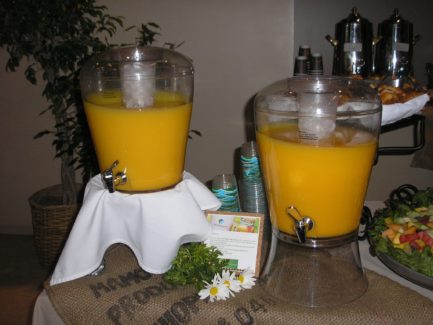 Two drinks are in a glass container on the table.