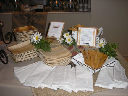 A table with plates, napkins and flowers on it.