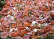 A large salad with tomatoes, onions and feta cheese.