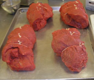 A tray of raw meat on top of a table.
