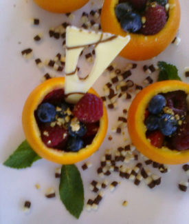 A plate of fruit with some nuts and cheese