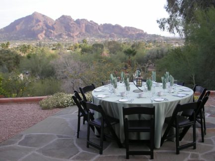 A table set for dinner with mountains in the background.