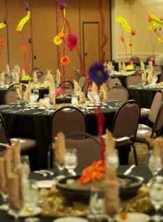 A room filled with tables and chairs covered in black cloth.