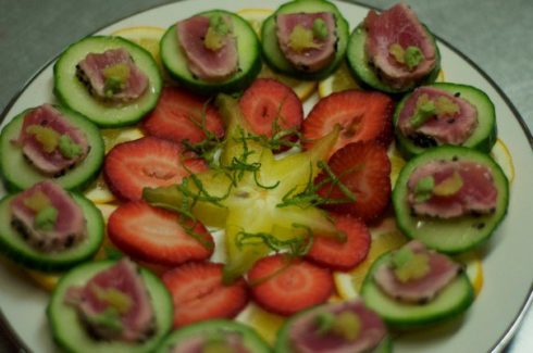 A plate of food with cucumbers and strawberries.