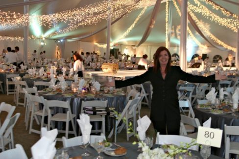 A woman standing in front of a large table.