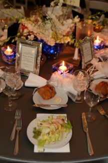 A table set with plates of food and candles.